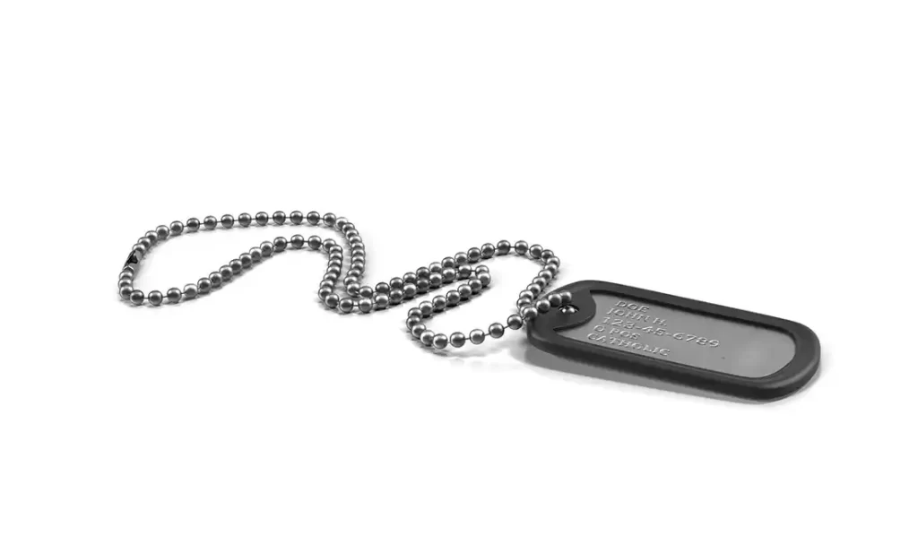 Metal military dog tags sandblasted for surface preparation and refinishing